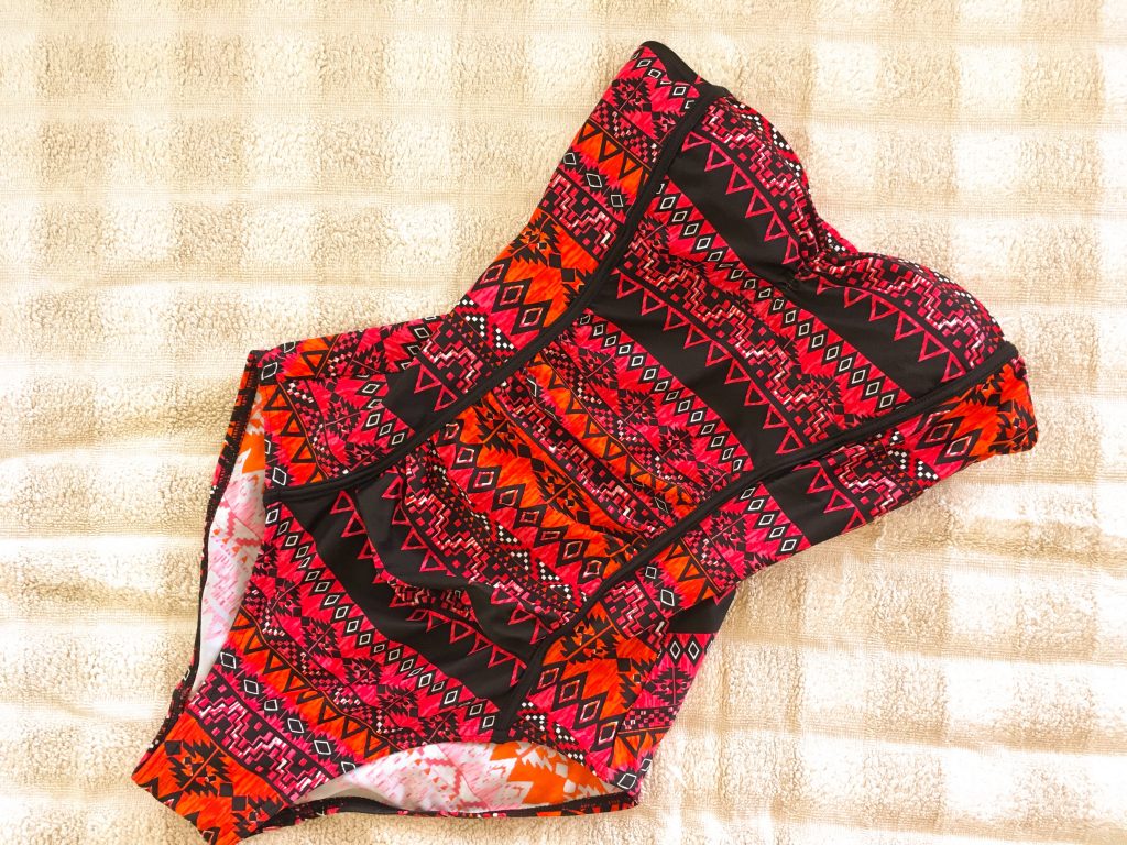 remove stains on swimwear - red swimsuit drying on towel