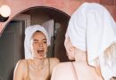 girl with towel in hair sticking tongue out in mirror