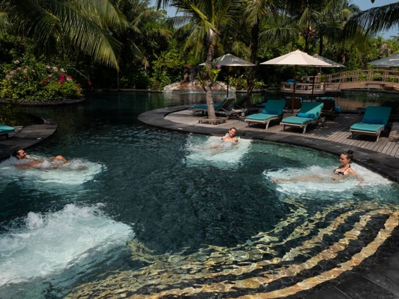 people relaxing in jacuzzi jet swimming pool in maldives