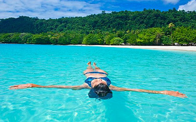 top 5 best beach getaways for summer around the world champagne beach vanuatu girl floating in sea 