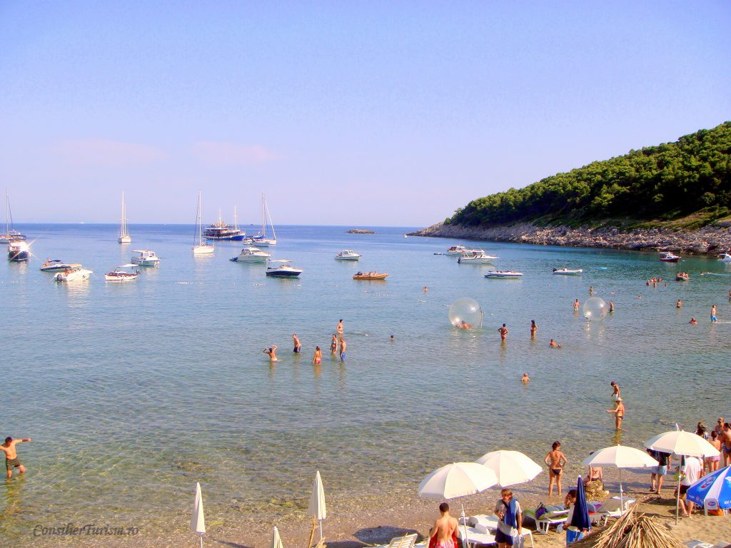 monthly beach getaways worldwide july in lopud island croatia beach with people in sea, on the beach and boats