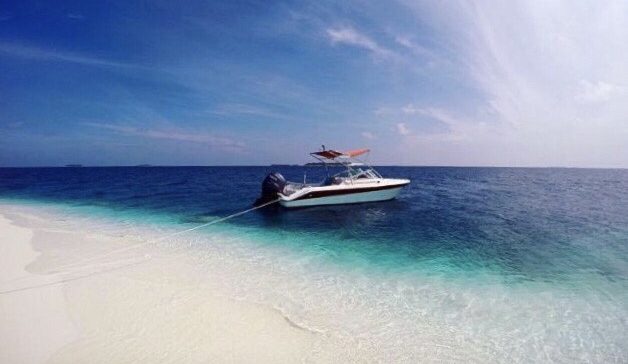 speedboat in clear water white sand beach