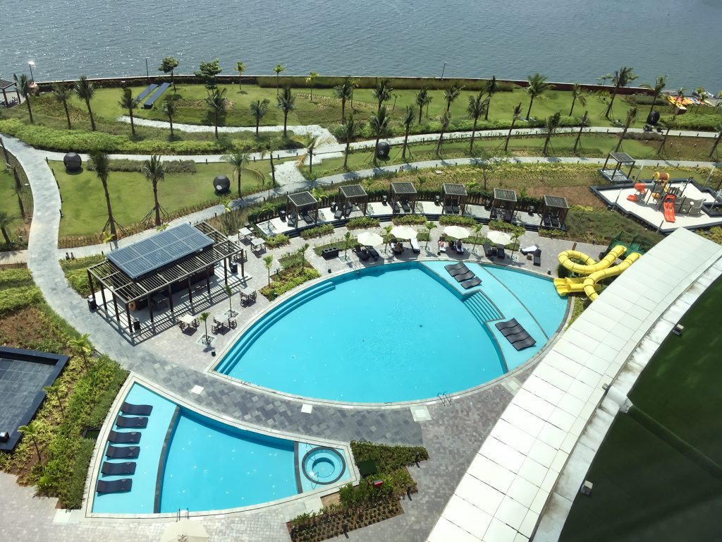 aerial view of the main swimming pool at Grand Hyatt Kochi with Lake Vembanad in the background