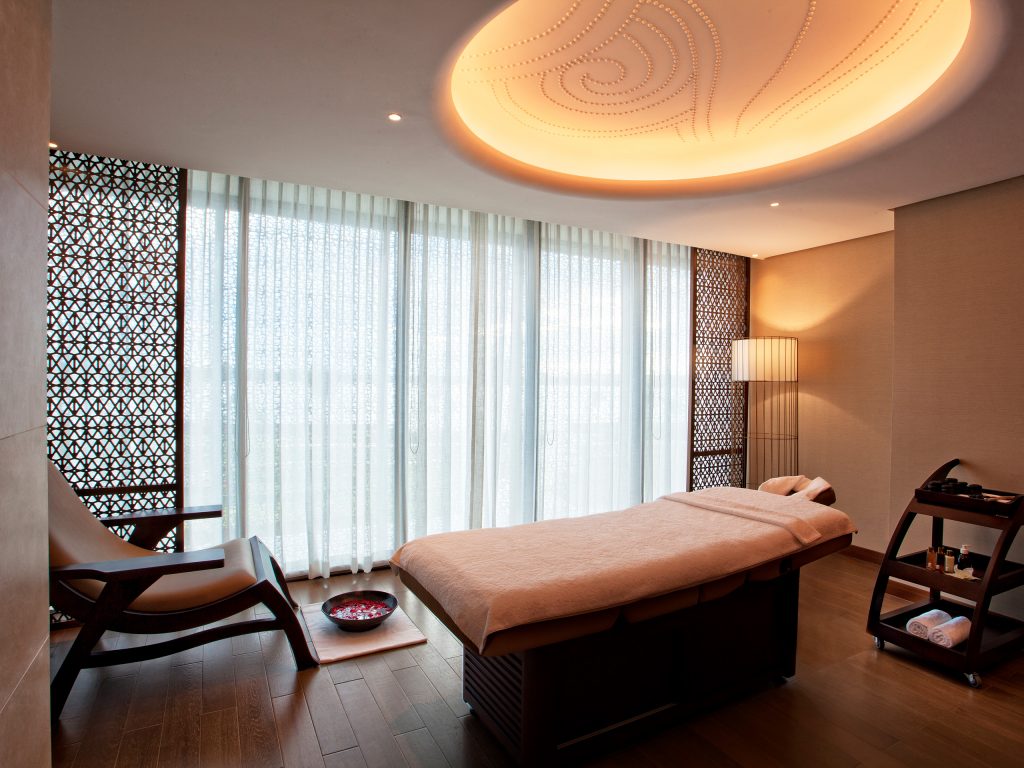 inside Santata spa treatment room with bed and a chair with footbath