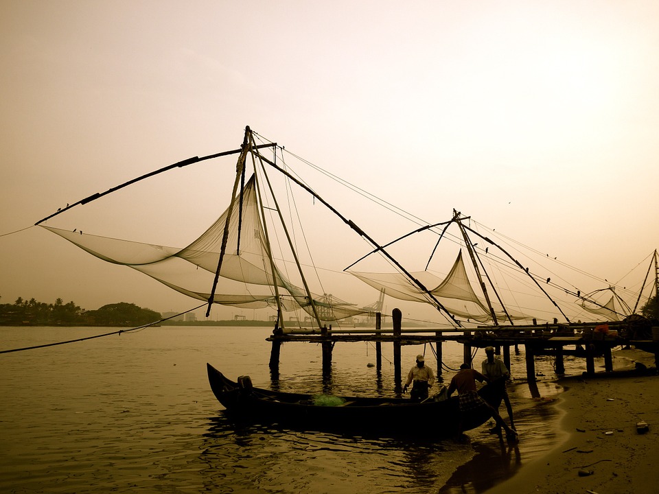 fishermen next to chinese fishing nets in kochi