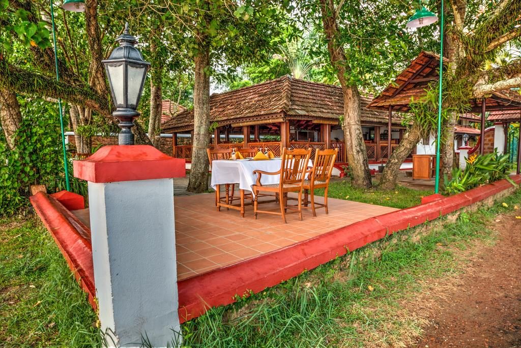tables for outdoor dining at the aymanam restaurant surrounded by trees