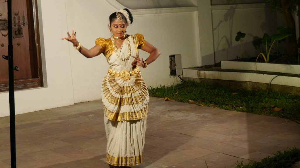 indian girl in full costume performing cultural dance