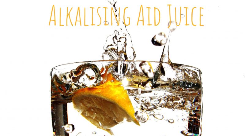 alkaline aid juice recipe cover photo with lemon splashed into a glass of water