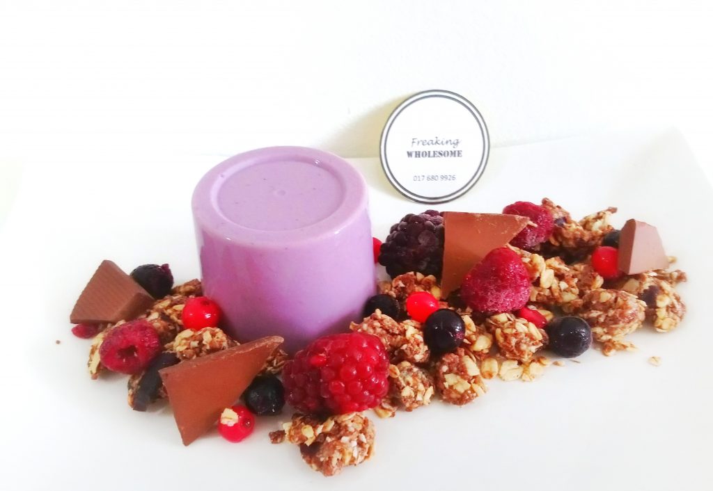 purple vegan, gluten-free acai berries panna cotta surroundeed by chocolate and berries