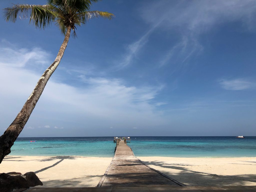 lang tengah island blue skies and white sand beach with boardwalk into the blue sea