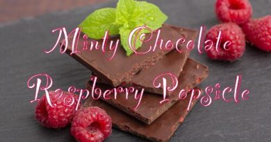 dark chocolate with mint leaves and fresh raspberries on a stone board