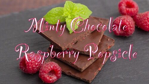 dark chocolate with mint leaves and fresh raspberries on a stone board