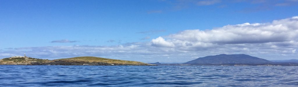 panaromic view of montague island with mount gulaga in the background