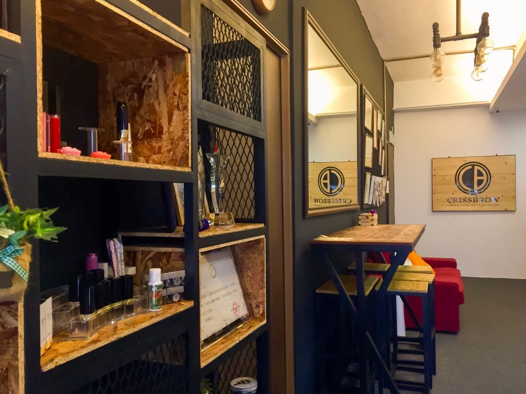 interior of crissbrow embroidery academy with display shelves of awards and products