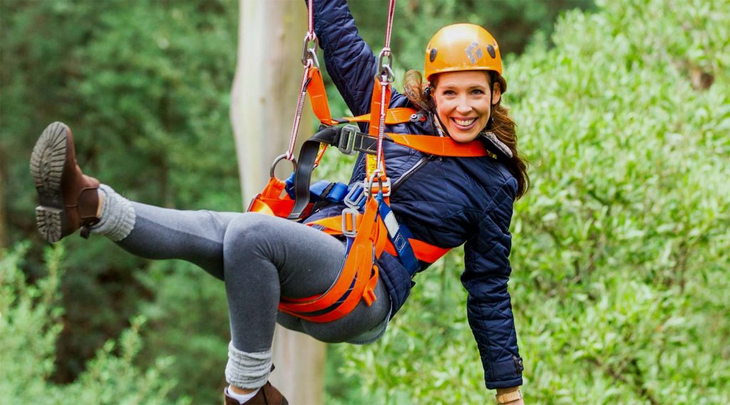 woman ziplining amongst trees in Otway Victoria