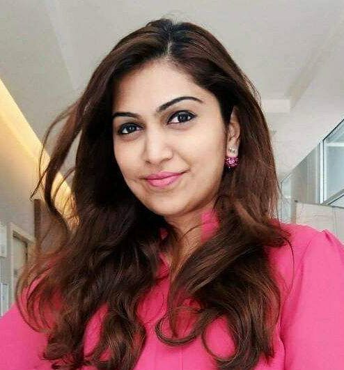 Dr Lashela Darmadass in a pink shirt posing in clinic