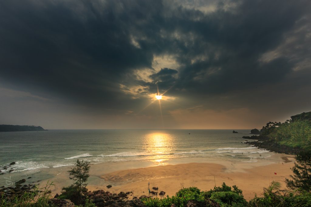 sunset under grey cloudy sky over a serene cabo de rama beach in goa