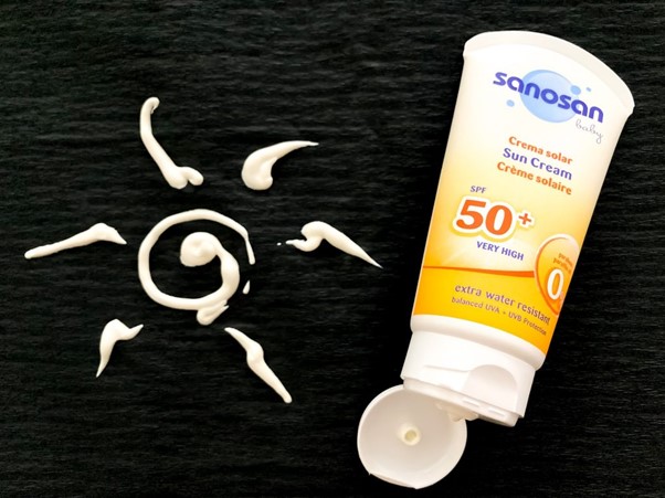 sun drawn out on black background using sunscreen