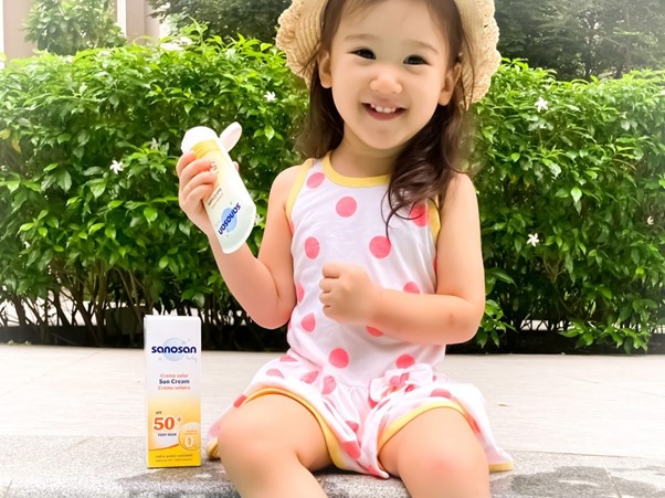 best baby sunscreen in malaysia, happy toddler holding sunscreen outdoors