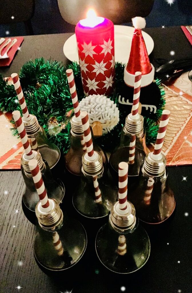 lightbulb glasses filled with mulled wine christmas cocktail with festive decorations