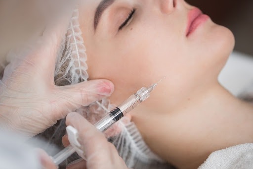 aesthetic clinic skin booster injectable procedure with syringe in cheeks